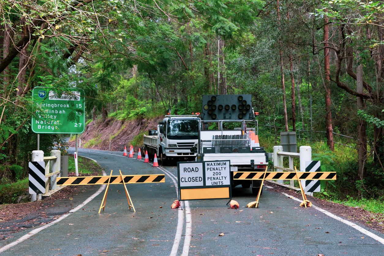 A blocked road with trees either side.