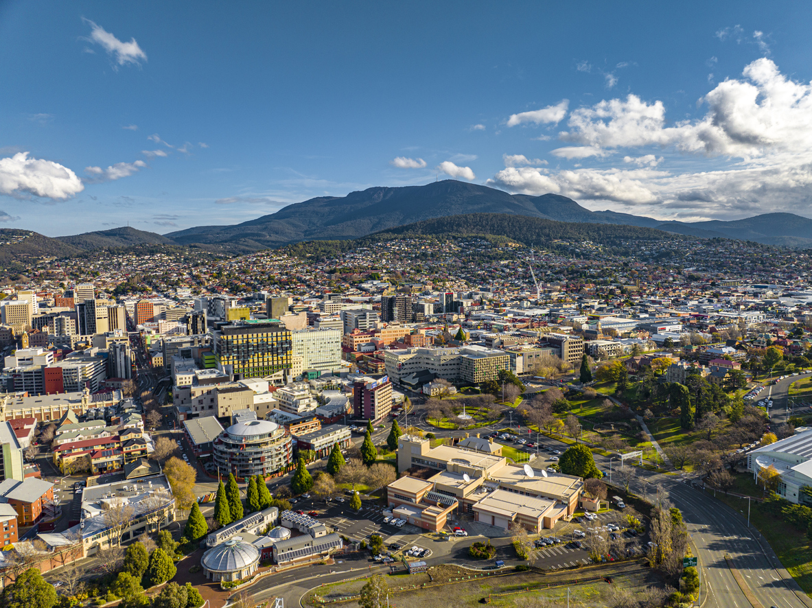 An aerial view of a business district and large mountain in the background.