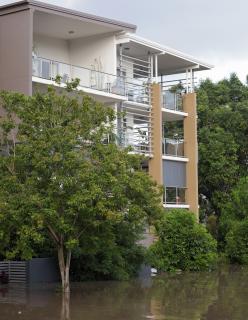 An apartment building with flooded water at the ground level.