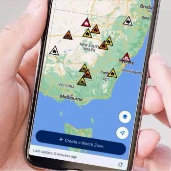 A person holding a phone with a map of NSW and hazard icons across the state.