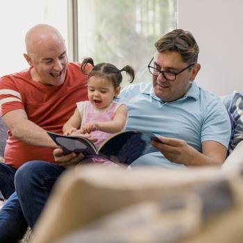 A family read a book together on the couch.