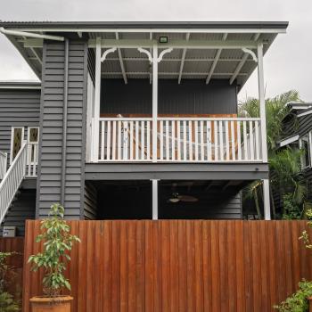 A renovated two storey Queenslander style home with fresh stained timber panelling.