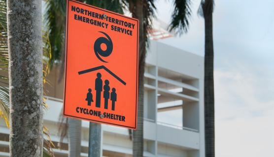 A sign attached to a pole notifying Northern Australia residents of a cyclone shelter.