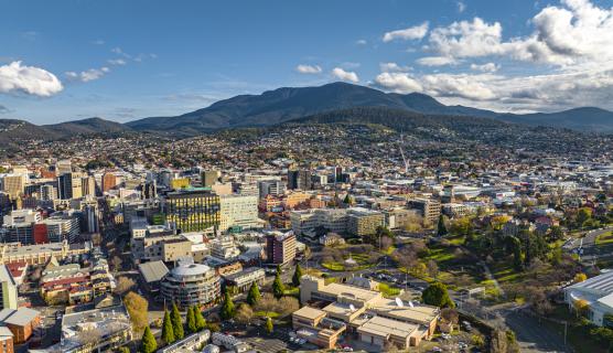 An aerial view of a business district and large mountain in the background.