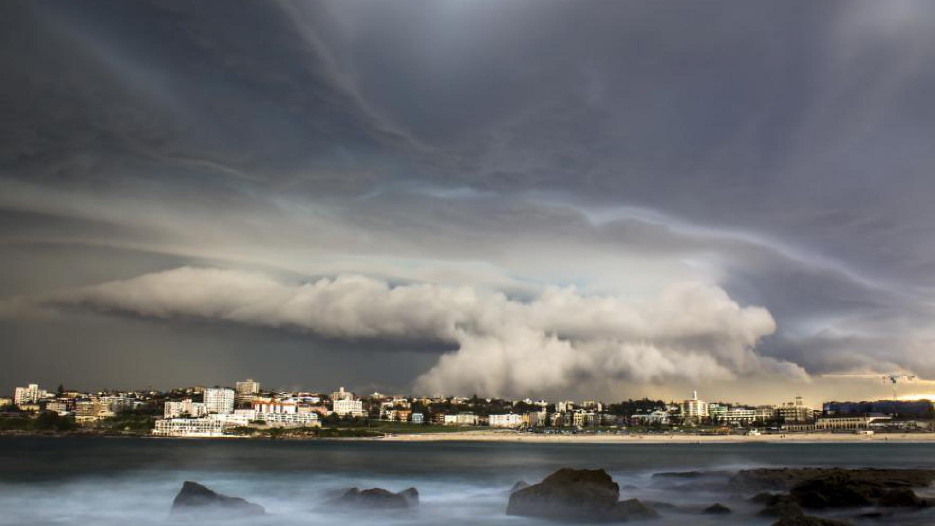 Image of cloudy skies over a coastal Australian town.