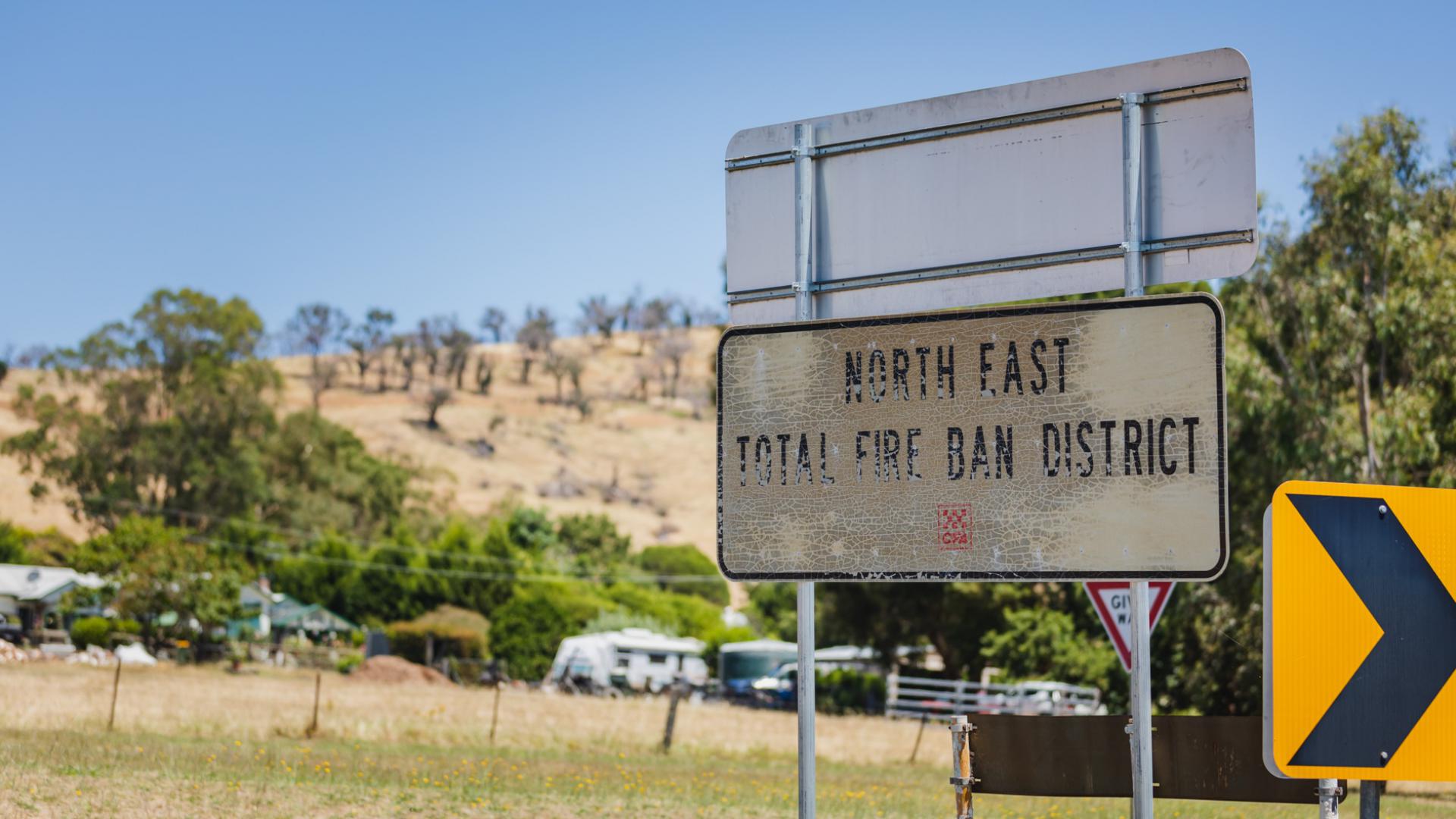 Image of a damaged road sign in Australia which has been previously burnt by a bushfire.