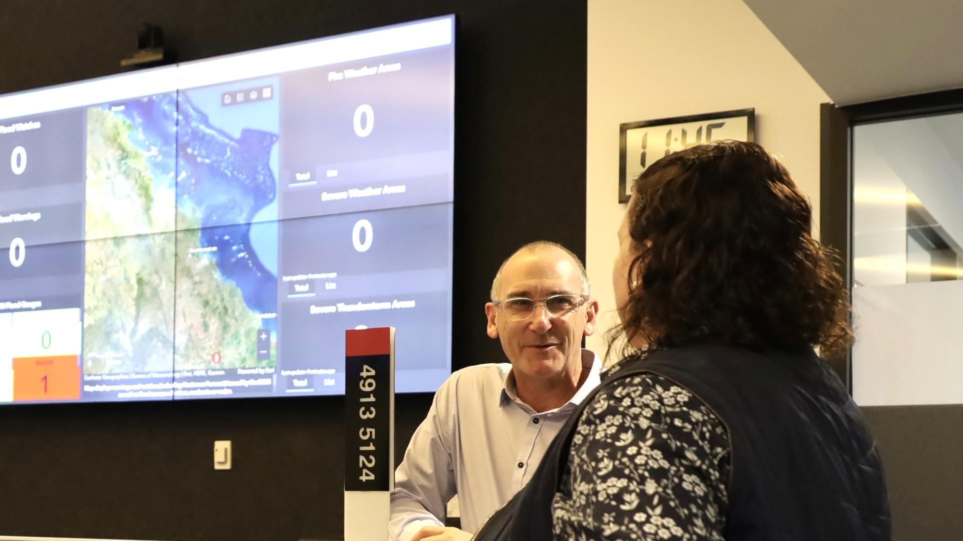 Two people are discussing in front of an incident map on a large screen at the Livingstone’s Shire Coordination Centre