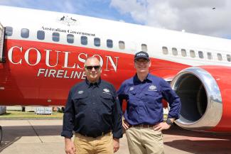 A photo of two men in front of a National Boeing 737 Large Air Tanker 