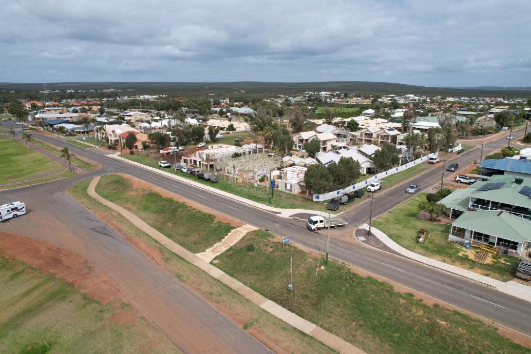 Drone shot looking over the town of Kalbarri showing neighbourhood with houses in construction and grey skies.