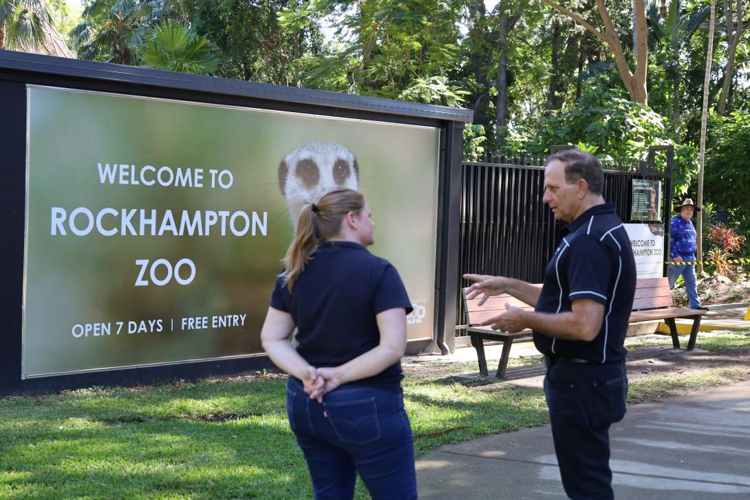 Two people standing outside the entry to Rockhampton Zoo, Queensland
